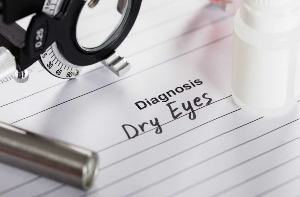 A close up of a lined piece of paper with optometric equipment laying on top of it and the term diagnosis in the middle with the words dry eyes handwritten underneath.