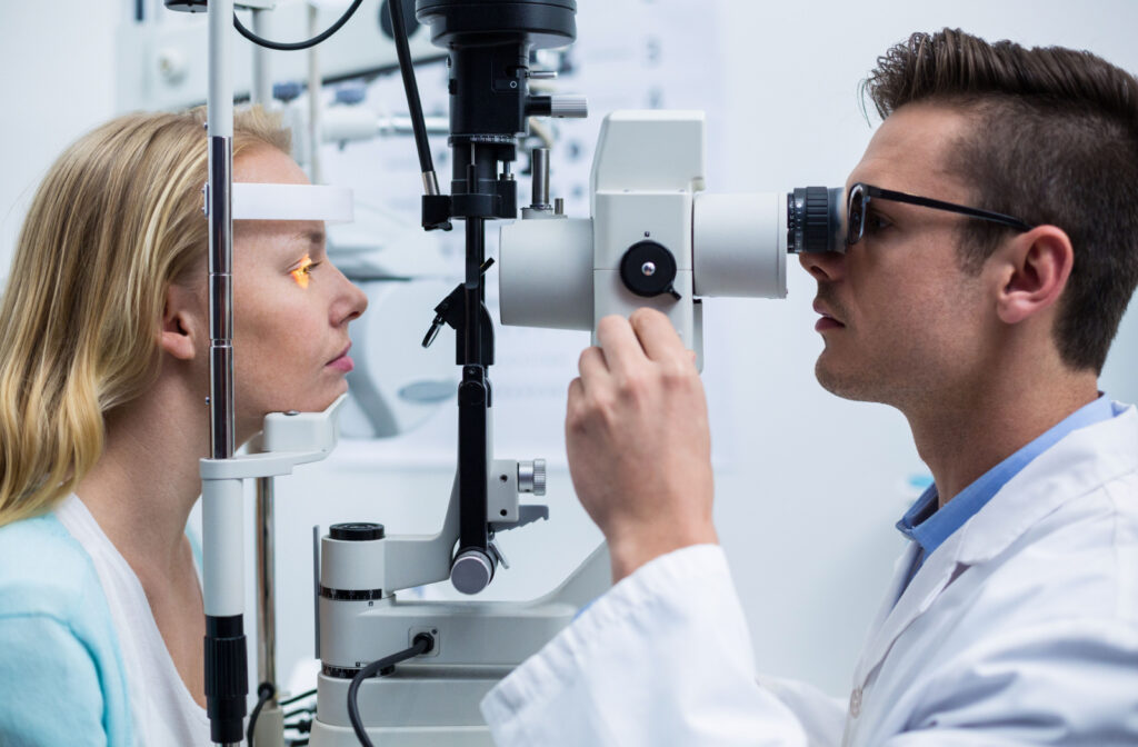 A male optometrist using a slit lamp to check a patient's eye