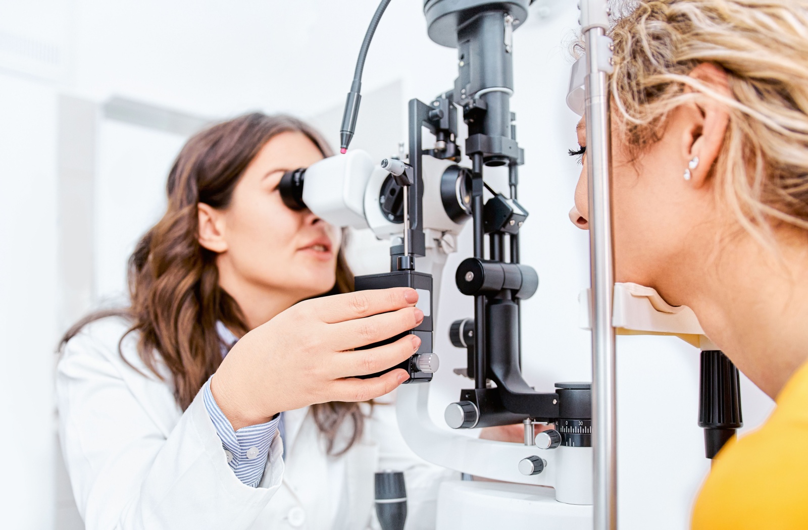 An optometrist conducting an eye exam with a female patient