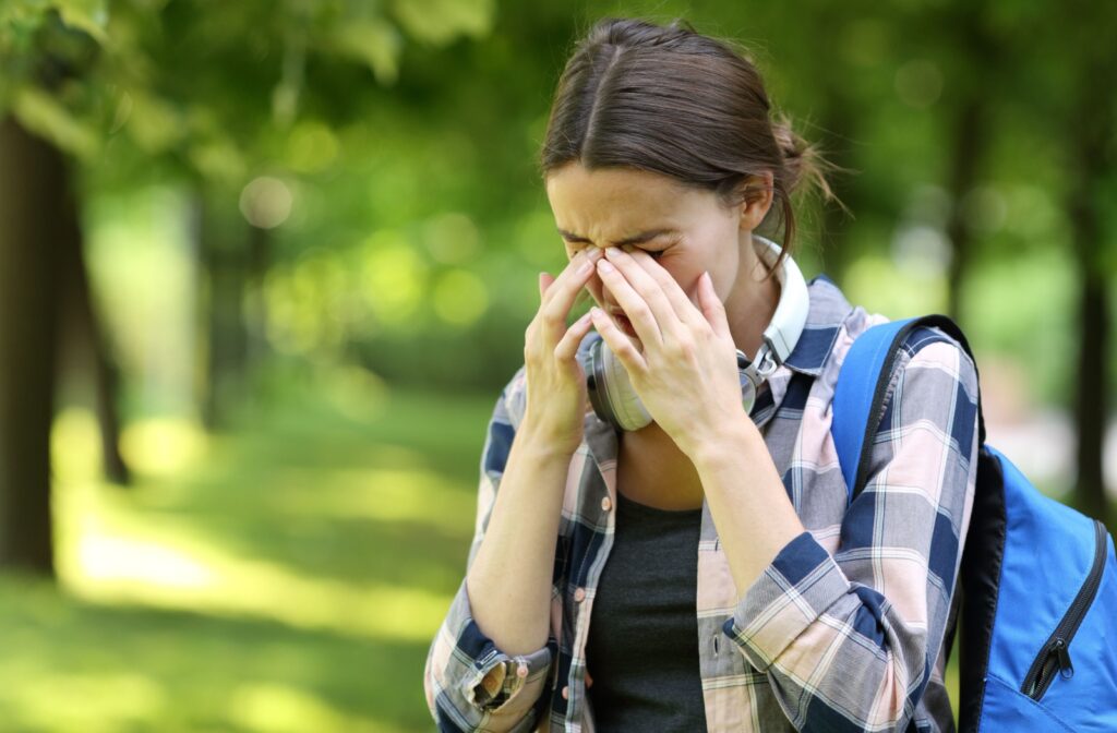 Person outdoors suffering from eye allergies.