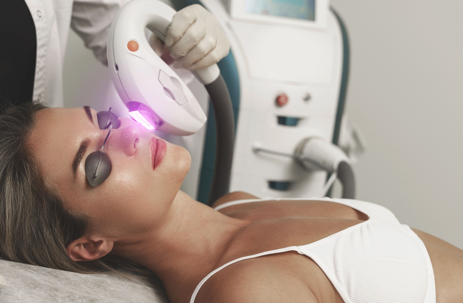 Patient receiving an IPL photofacial treatment with a handheld light device applied to the face.