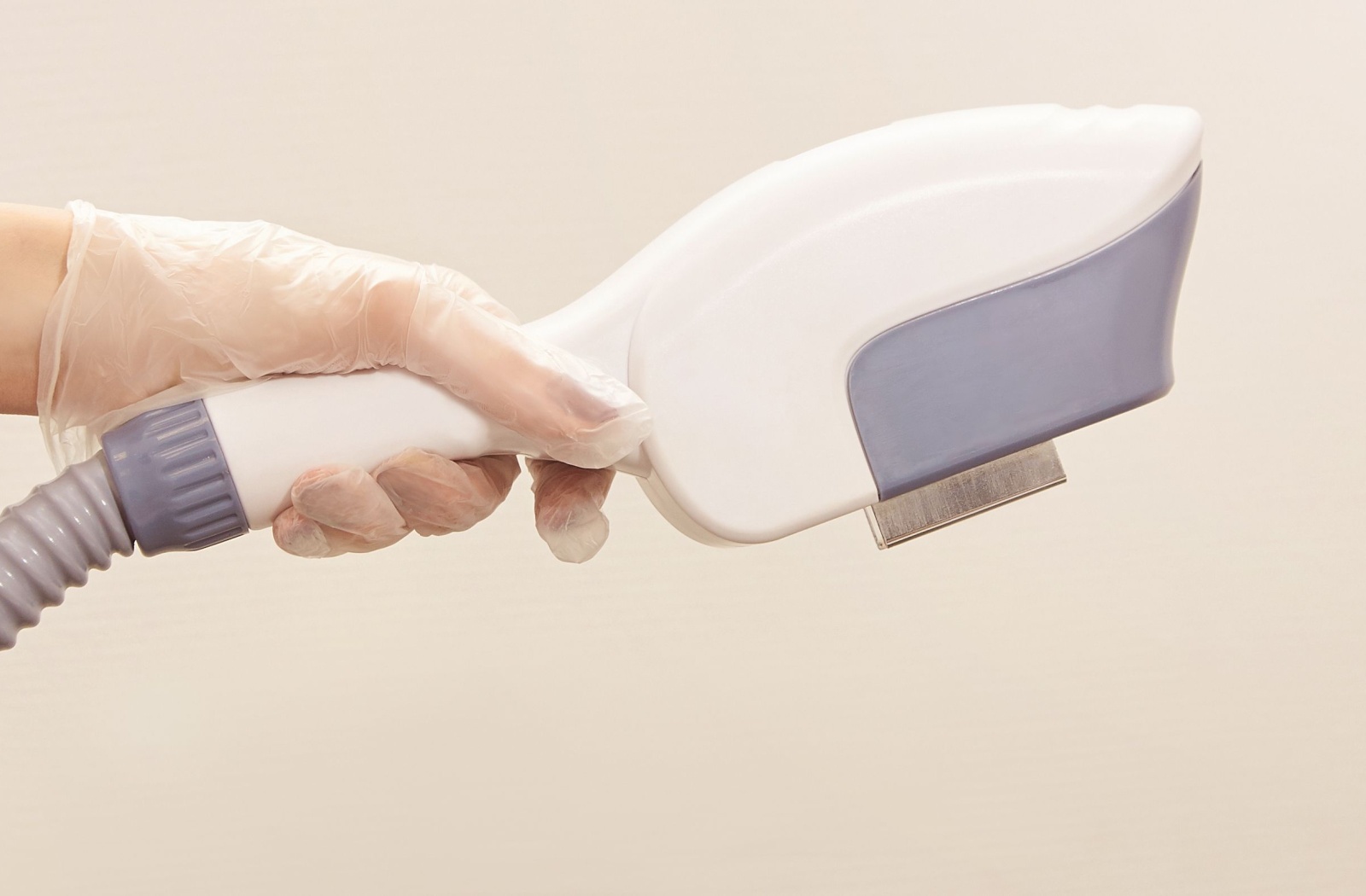 Hand holding an IPL device used in dry eye treatment to target inflammation and meibomian gland dysfunction.