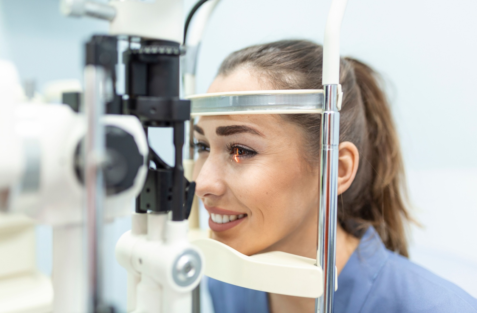 Woman having a slit-lamp eye exam during a comprehensive eye assessment at the optometrist.